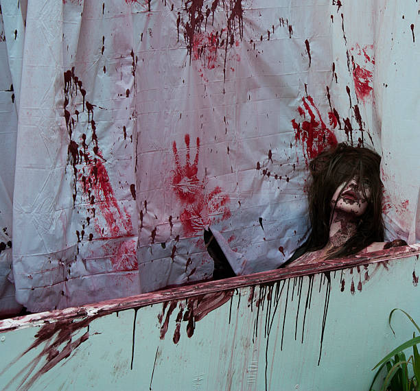 Dead bloody woman in bathtub with bloody handprints on shower curtain taken in Salem Massachusetts .