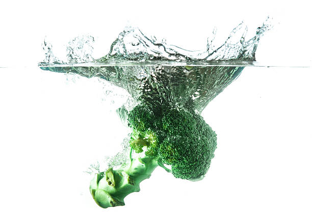 istock Green broccoli falling in water on white with air bubbles 462136141