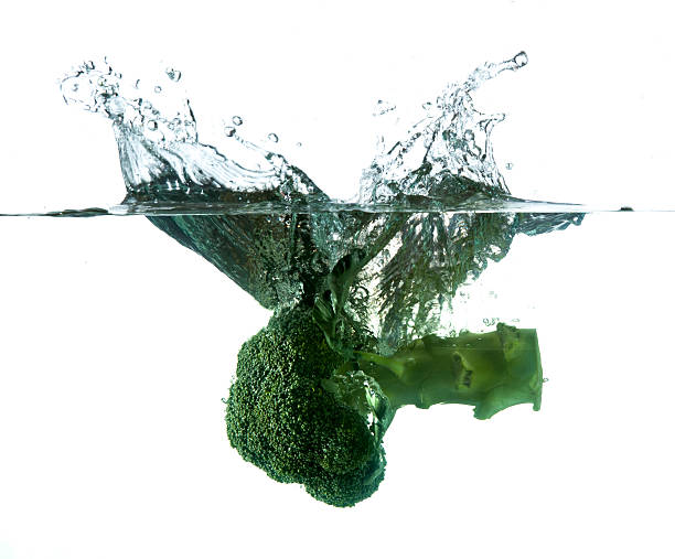 istock Green broccoli falling in water on white with air bubbles 462136887