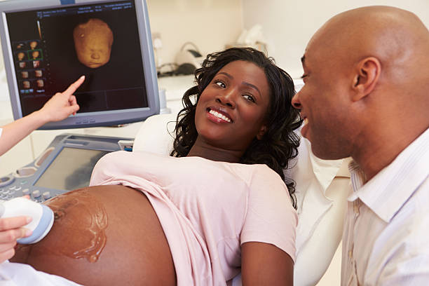 mujer embarazada y pareja con ecografía 4d - ultrasound human pregnancy ultrasound machine doctor fotografías e imágenes de stock