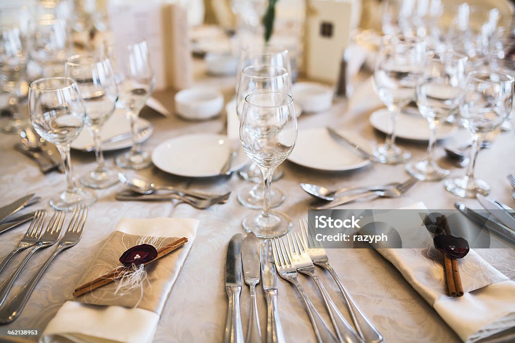 Table setting for event Close up of a table arranged for an event with beige tablecloth and napkins decorated with cinnamon Fish Knife Stock Photo