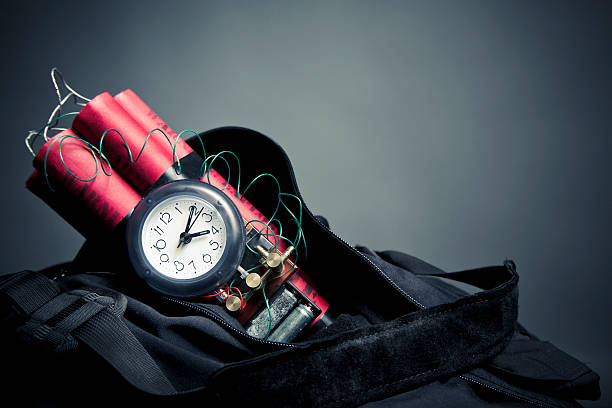 Time bomb sticking out of backpack on grey background timebomb in a backpack representing terrorist attack terrorism stock pictures, royalty-free photos & images