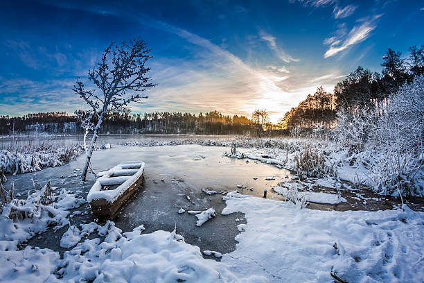 istock Old boat on the lake covered with snow in winter 462153783