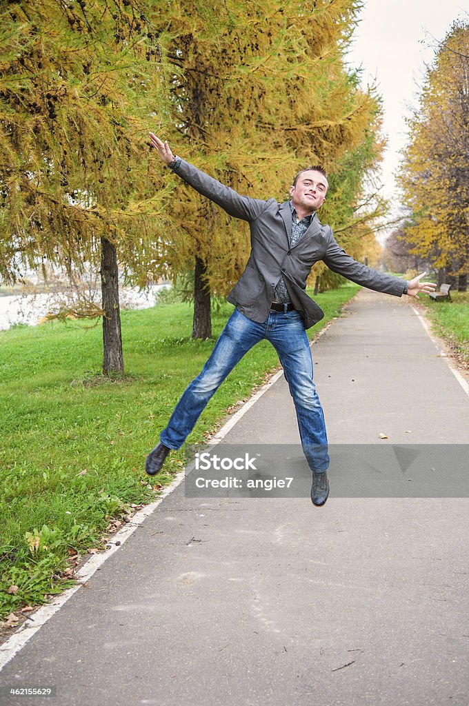 Young man jumping in autumn park Young handsome man jumping in autumn park Activity Stock Photo