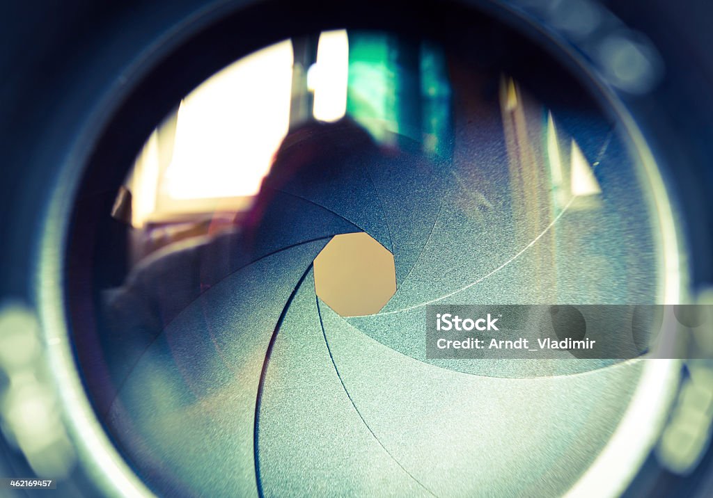 The diaphragm of a camera lens aperture. The diaphragm of a camera lens aperture. Selective focus with shallow depth of field. Color toned image. Lens - Optical Instrument Stock Photo