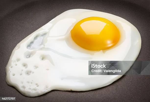 Closeup Of A Fried Egg On A Black Surface Stock Photo - Download Image Now - Fried Egg, Animal Egg, Egg - Food