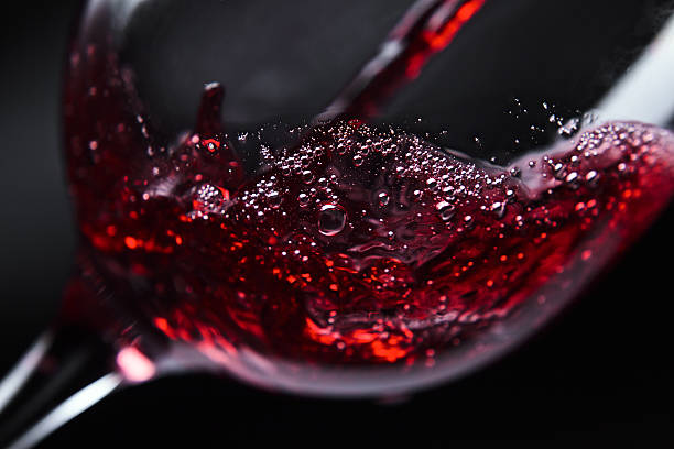Red wine being poured into wine glass stock photo