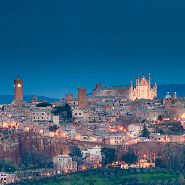 Orvieto in the night Orvieto's cliff. Orvieto is a city in southwestern Umbria, Italy situated on the flat summit of a large butte of volcanic tuff. The site of the city is among the most dramatic in Europe, rising above the almost-vertical faces of tuff cliffs that are completed by defensive walls built of the same stone called Tufa. orvieto stock pictures, royalty-free photos & images