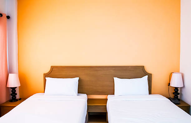 Twin beds with bedside table and lamp.