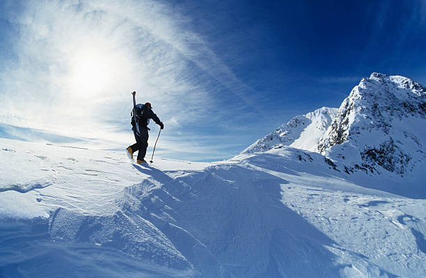 istock Lone skier hiking the snow-covered mountain summit 462203847