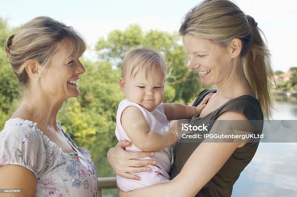 Three Female Generation Family Grandmother with mother and daughter against the lake Baby - Human Age Stock Photo