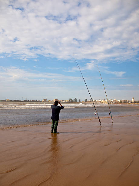 Moroccan fisherman with two rods standing on the shore