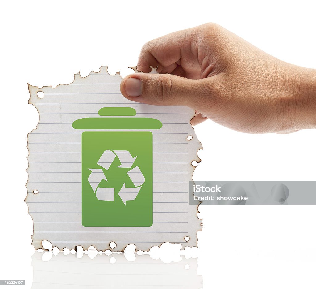 Hand holding piece of burned paper on white background. Hand holding piece of burned paper on white background(green recycle bin) Backgrounds Stock Photo