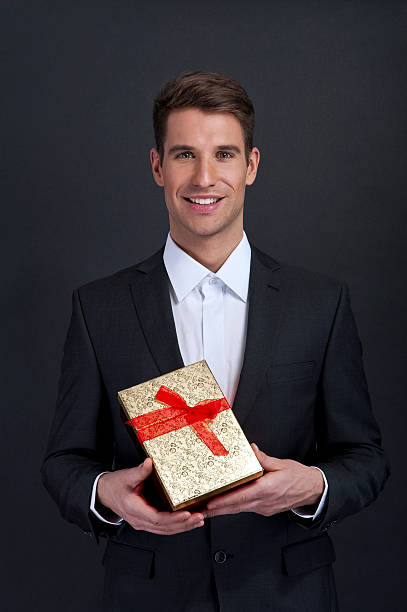 close up of man hands holding gift box stock photo