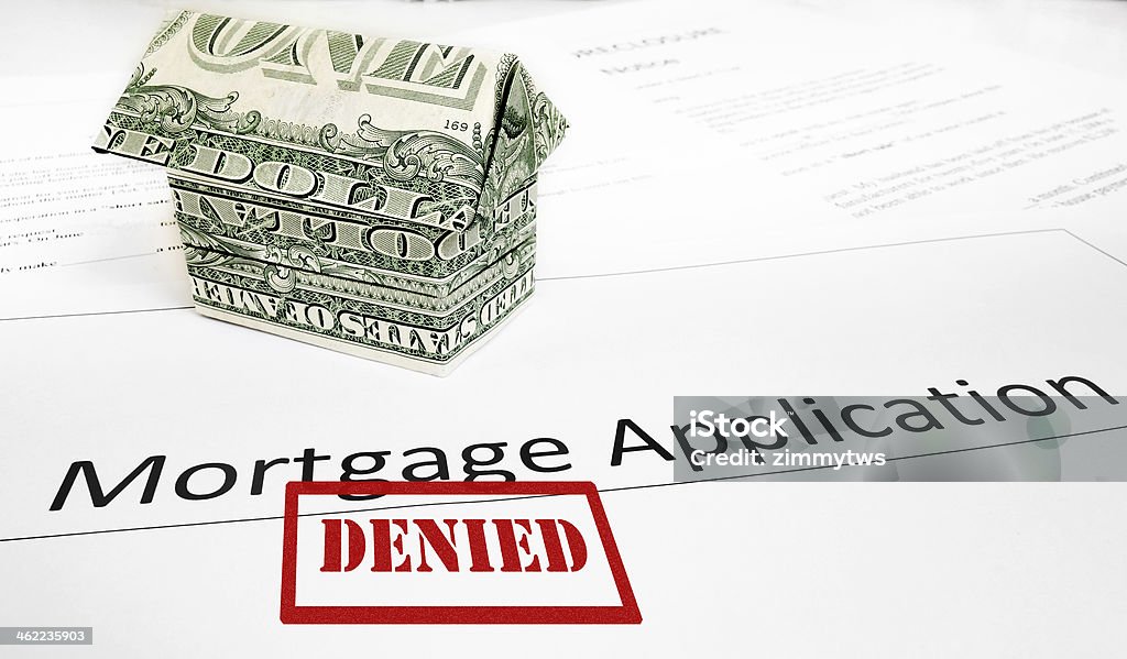 Denied mortgage app A Denied mortgage application with an origami dollar house Deterioration Stock Photo