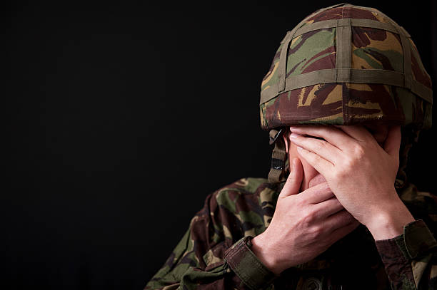 istock A soldier hiding his face on black background 462241089