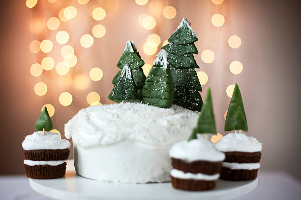 Christmas cake with snow and chocolate Christmas cake with lights on the background christmas cake stock pictures, royalty-free photos & images