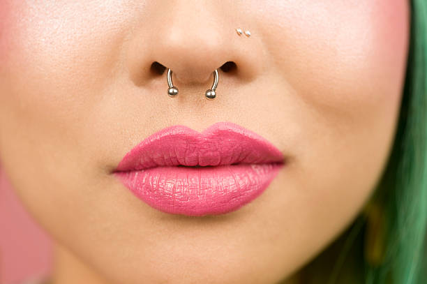 lèvres de jeune femme avec rouge à lèvres rose - pierced photos et images de collection