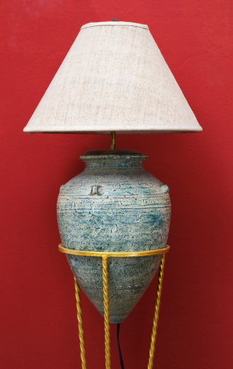antique pottery lamp on red wall background