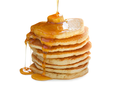 A stack  of pancakes with maple syrup and melted butter. Isolated on white..
