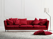 Red leather couch in a room with white walls