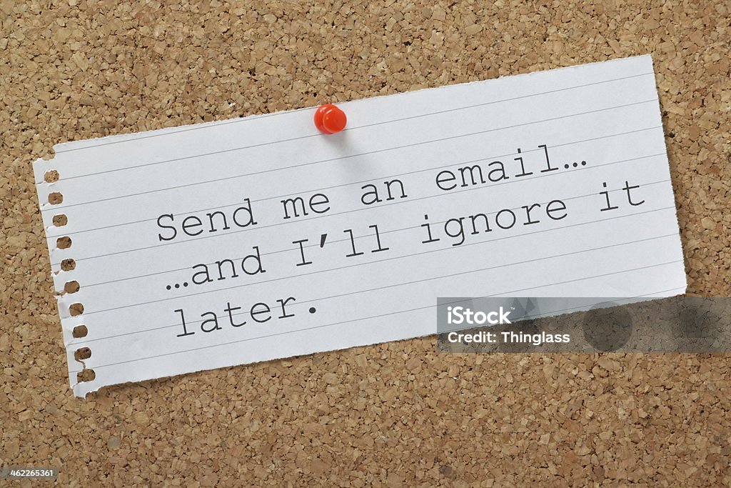 Email Concept The phrase Send me an email and I'll Ignore it Later on a cork notice board. A concept for time wasting or avoiding being overwhelmed by communications and workload. Communication Stock Photo