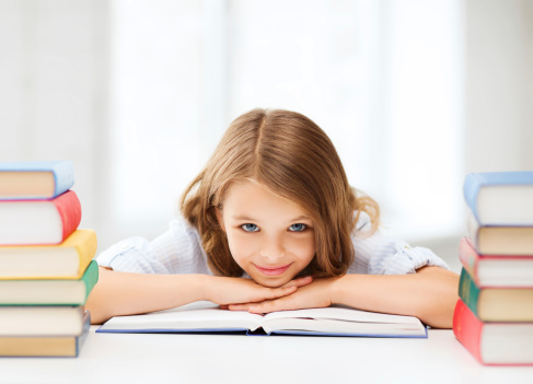 education and school concept - smiling little student girl with many books at school