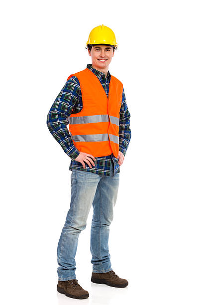 Construction worker with orange vest and yellow hat smiling Smiling construction worker in yellow helmet and orange waistcoat. Full length studio shot isolated on white. waistcoat stock pictures, royalty-free photos & images