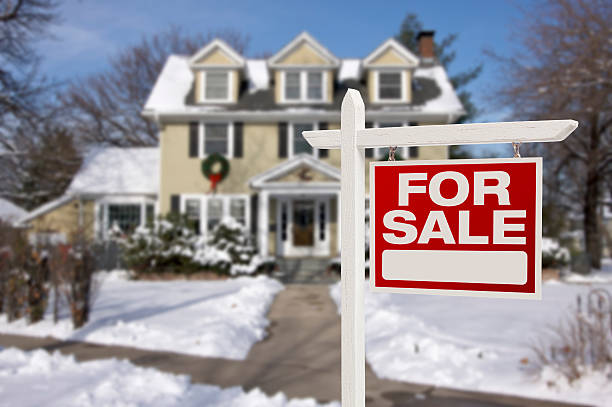 Home For Sale Sign in Front of Snowy New House stock photo