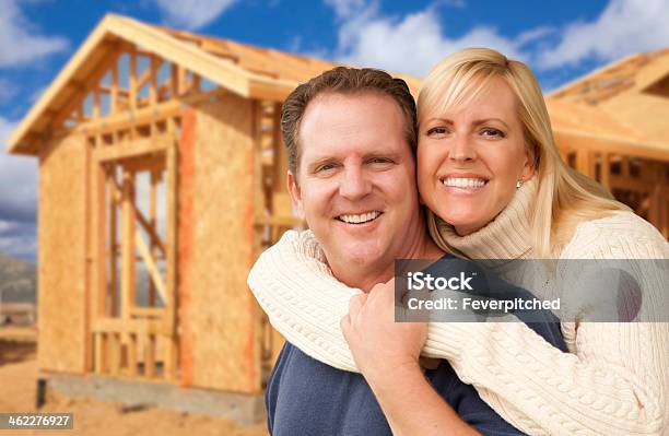 Couple In Front Of New Home Construction Framing Site Stock Photo - Download Image Now