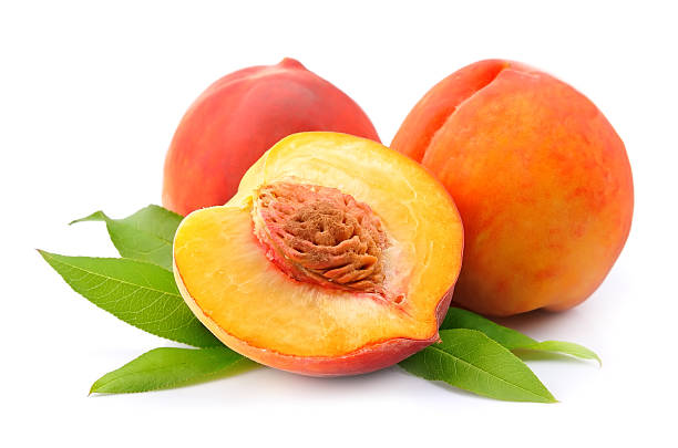 istock A halved and whole peaches with leaves isolated on white 462290863