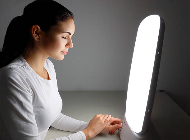 Light therapy at home The new way to combat winter depression - recharge sunlight with a daylight lamp and thus compensate for the light deficit in winter. light therapy stock pictures, royalty-free photos & images