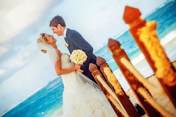 istock Bride and groom embrace at the beach 462294593