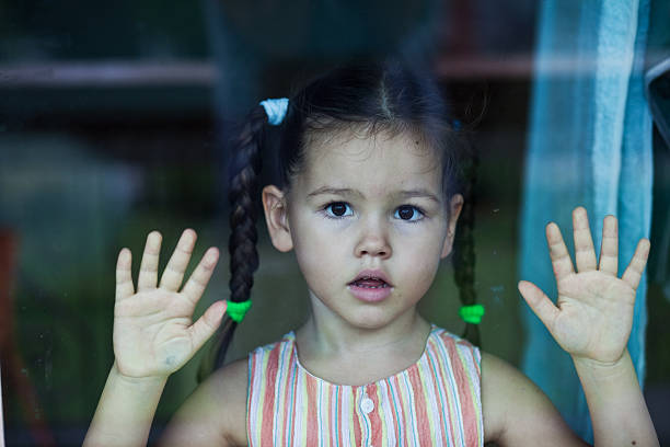 chica espera junto a la ventana - displeased child abandoned child abuse fotografías e imágenes de stock