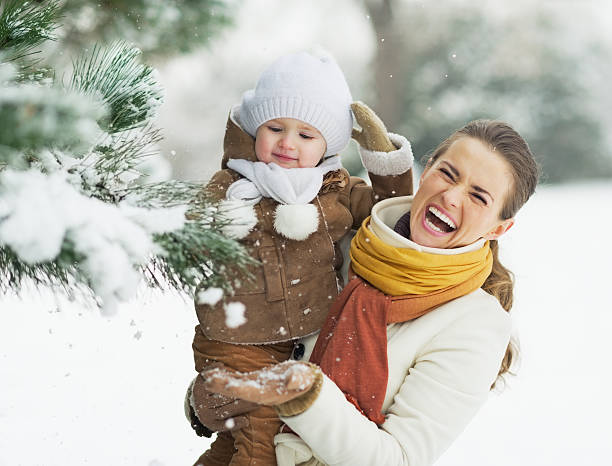 istock Happy mother and baby playing with snow on branch 462302013