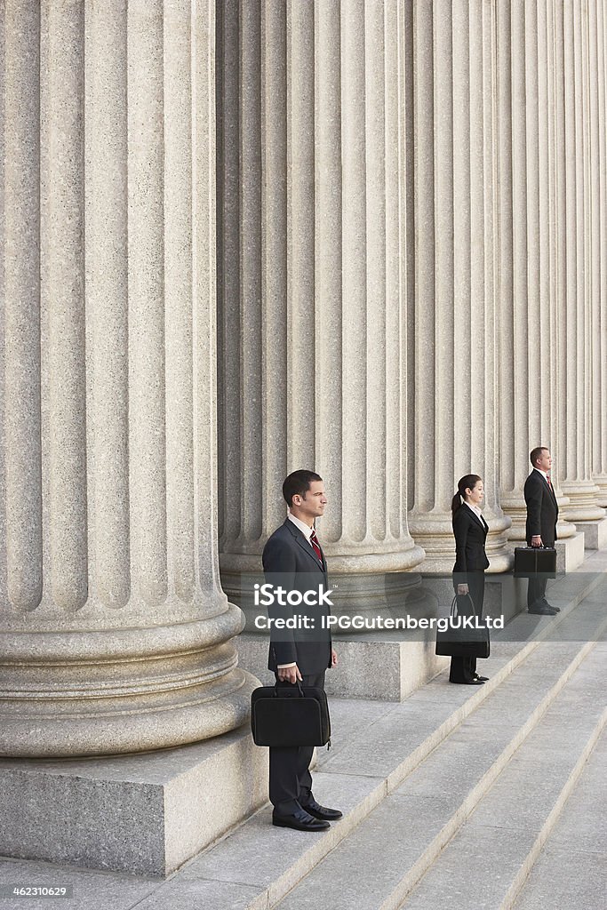 Attorneys Waiting On Courthouse Steps Full length side view of three attorneys waiting on courthouse steps Legal System Stock Photo