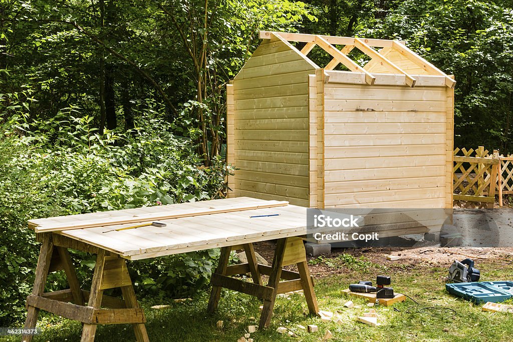 Construction of a wooden hut Construction of a wooden hut in a garden Building - Activity Stock Photo