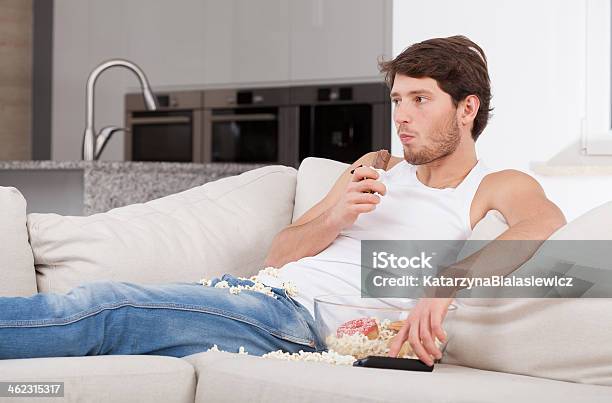 Bored Man Lying On Couch Stock Photo - Download Image Now - Eating, Men, Sofa