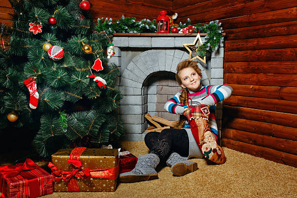 istock Girl sitting near Christmas tree 462318087