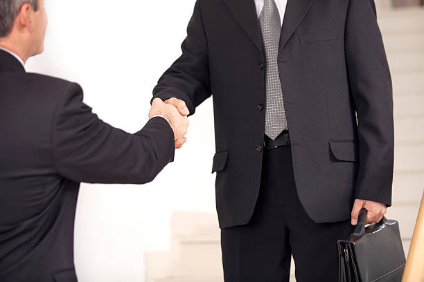 istock Handshake. Two business men in formalwear handshaking on staircase 462322857