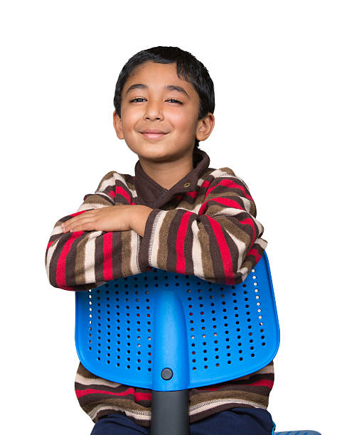 Portrait of a Smiling Little Boy Sitting Reverse on Chair stock photo