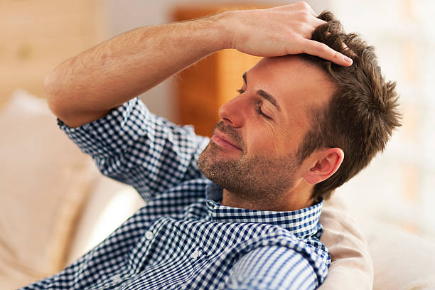 homme souriant avec la main dans les cheveux - main dans les cheveux photos et images de collection