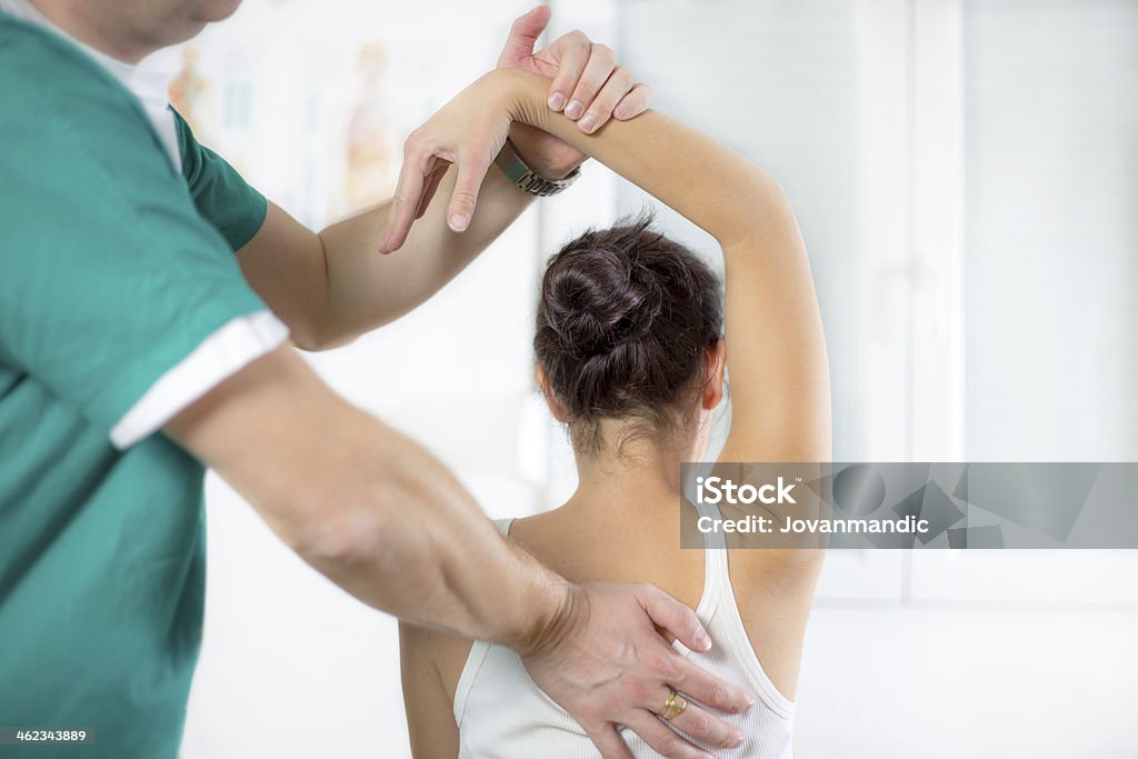 Physical Therapist Series: shoulder mobility Osteopath or Physiotherapist treating her patient's arm and shoulder Chiropractic Adjustment Stock Photo