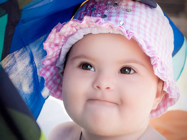 Baby girl wearing a pink hat stock photo