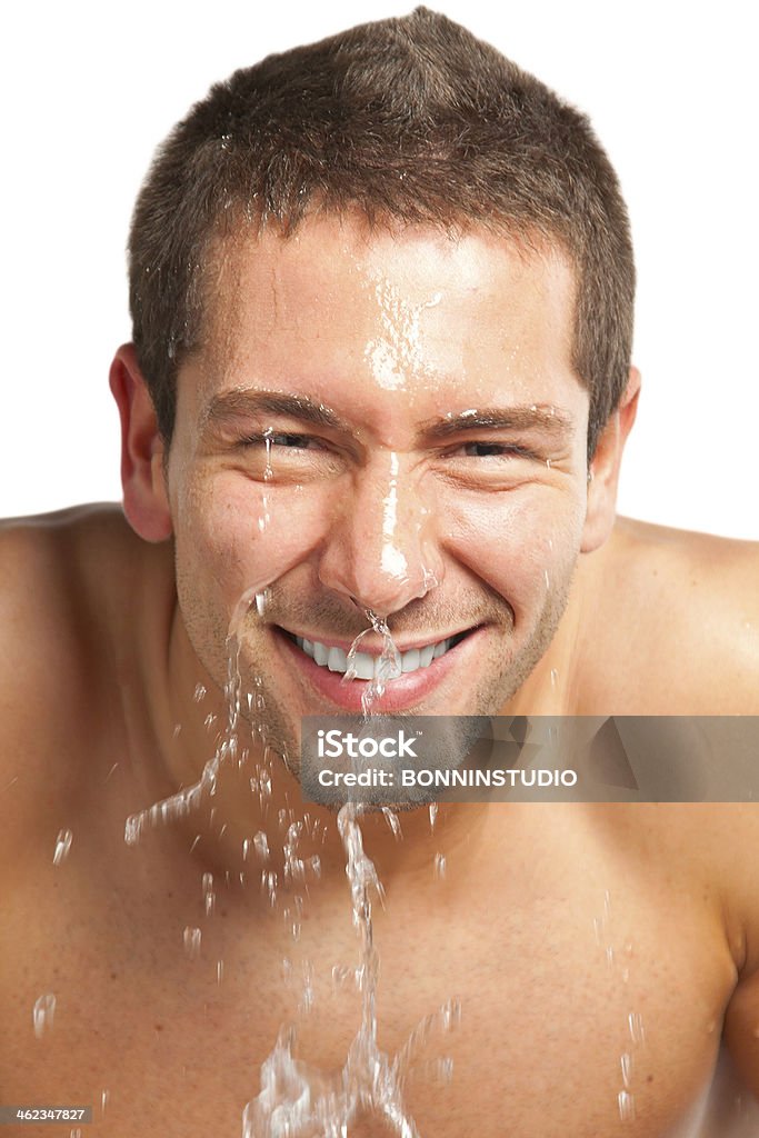 Young man spraying water on his face after shaving Young man splashing water on his face Abdomen Stock Photo