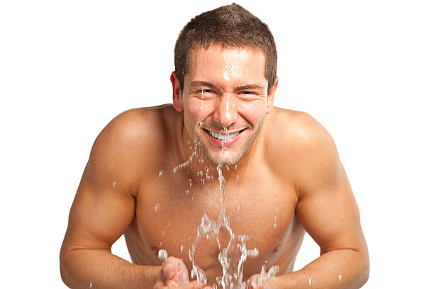 若い男性の水が吹きかけるに顔のシェービング - wet shave ストックフォトと画像