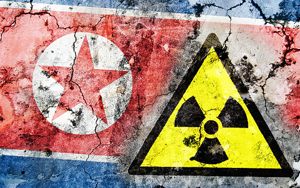 istock Old cracked wall with radiation warning sign and painted flag 462352041