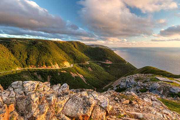 Cabot Trail Sunset The winding Cabot Trail road seen from high above on the Skyline Trail at sunset in Cape Breton Highlands National Park, Nova Scotia cabot trail stock pictures, royalty-free photos & images