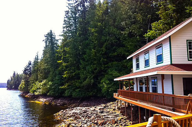 Scenic house near water and mountains stock photo