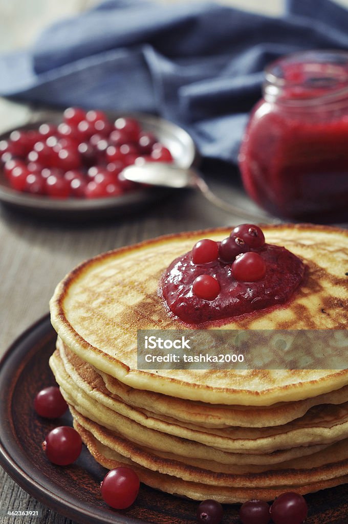 Pancakes with cranberry jam Delicious pancakes with cranberry jam on the wooden background Baked Pastry Item Stock Photo